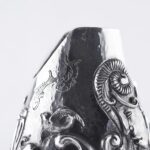Handcrafted by the florentine master goldsmith Giuliano Foglia, this isa detail of Fantasy Champagne bottle cover that has intricately chiseled a series of surrealistic images
