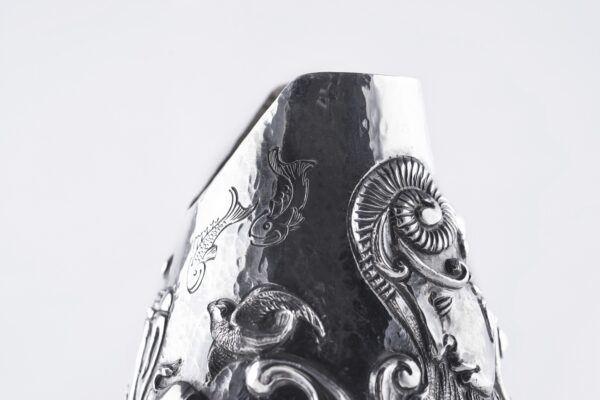 Handcrafted by the florentine master goldsmith Giuliano Foglia, this isa detail of Fantasy Champagne bottle cover that has intricately chiseled a series of surrealistic images