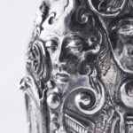 Handcrafted by the florentine master goldsmith Giuliano Foglia, this isa detail of Fantasy Champagne bottle cover that has intricately chiseled a series of surrealistic images
