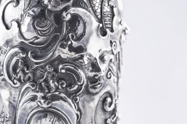 Handcrafted by the florentine master goldsmith Giuliano Foglia, this isa detail of Fantasy Champagne bottle cover that has intricately chiseled a series of surrealistic images