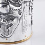 Handcrafted by the florentine master goldsmith Giuliano Foglia, this isa detail of Fantasy Champagne bottle cover that has intricately chiseled a series of surrealistic images