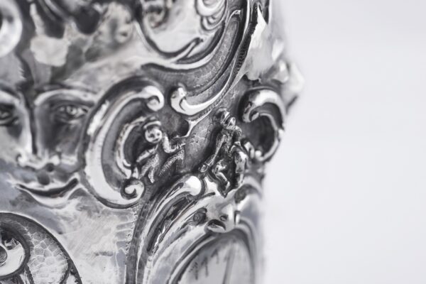 Handcrafted by the florentine master goldsmith Giuliano Foglia, this isa detail of Fantasy Champagne bottle cover that has intricately chiseled a series of surrealistic images