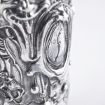 Handcrafted by the florentine master goldsmith Giuliano Foglia, this isa detail of Fantasy Champagne bottle cover that has intricately chiseled a series of surrealistic images