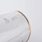 Detail of the Silver champagne bottle cover with bas-relief inspired by mythological bacchanal scene.