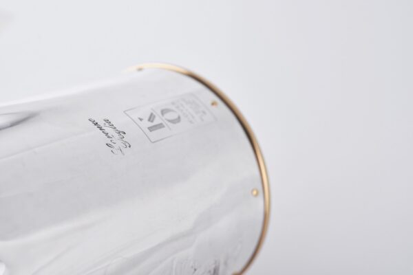 Detail of the Silver champagne bottle cover with bas-relief inspired by mythological bacchanal scene.