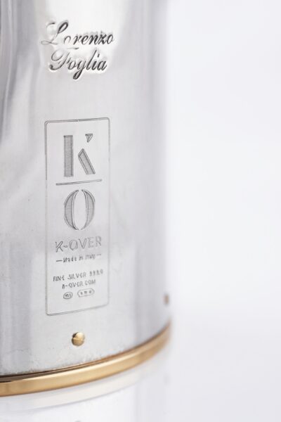 Detail of the Silver champagne bottle cover with bas-relief inspired by mythological bacchanal scene.