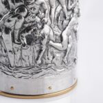 Detail of the Silver champagne bottle cover with bas-relief inspired by mythological bacchanal scene.