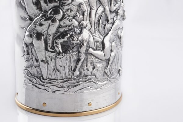 Detail of the Silver champagne bottle cover with bas-relief inspired by mythological bacchanal scene.