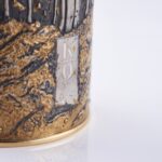 Detail of champagne bottle cover, engraved forest scene in autumn colors.