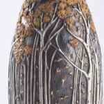 Detail of champagne bottle cover, engraved forest scene in autumn colors.