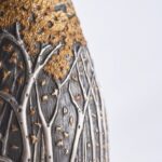 Detail of champagne bottle cover, engraved forest scene in autumn colors.