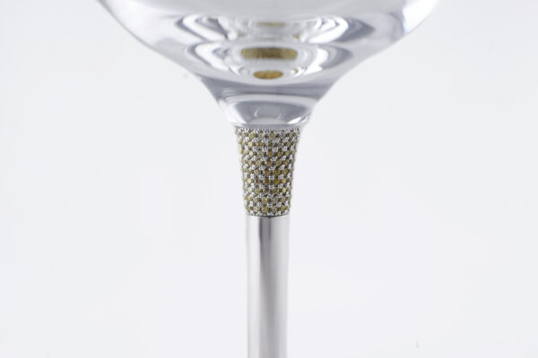 Detail of a luxury wine glass stem, featuring a section encrusted with small diamonds or crystals, set in a silver structure