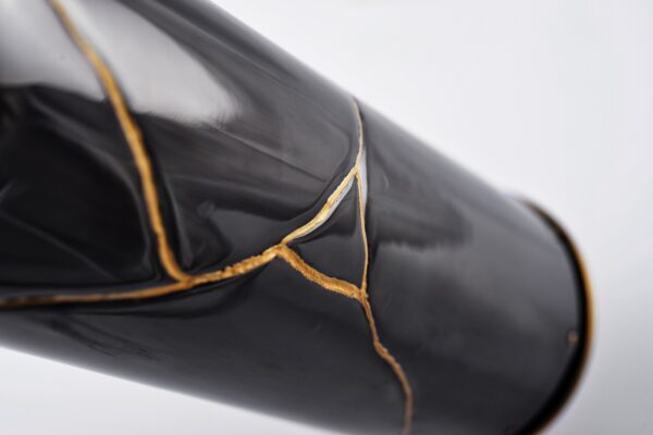 Detail of the Wine bottle cover Kintsugi Wine - Japan Memories: elegant black wine bottle cover inspired by the Japanese art of Kintsugi, with delicate gold cracks enhancing its surface, symbolizing beauty in imperfection and the value of unique stories