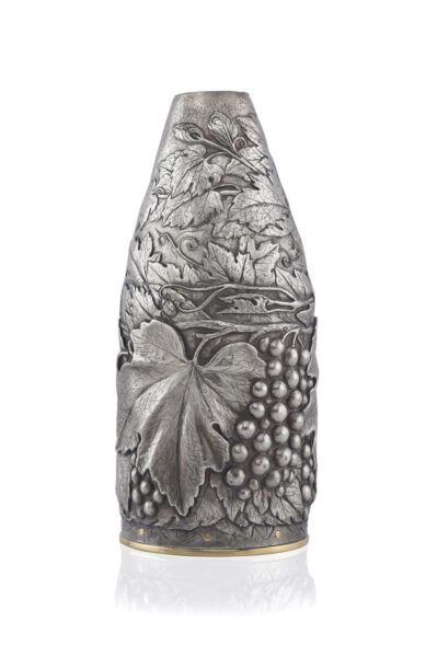 Champagne bottle cover in silver, finely engraved with vine leaves, tendrils, and grape clusters, highlighted by a gold-plated base