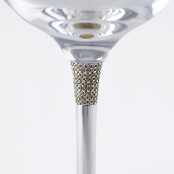 Detail of a luxury wine glass stem, featuring a section encrusted with small diamonds or crystals, set in a silver structure