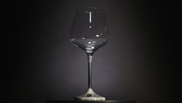 Close-up of a single silver wine goblet, finely engraved with grapevine and leaf motifs