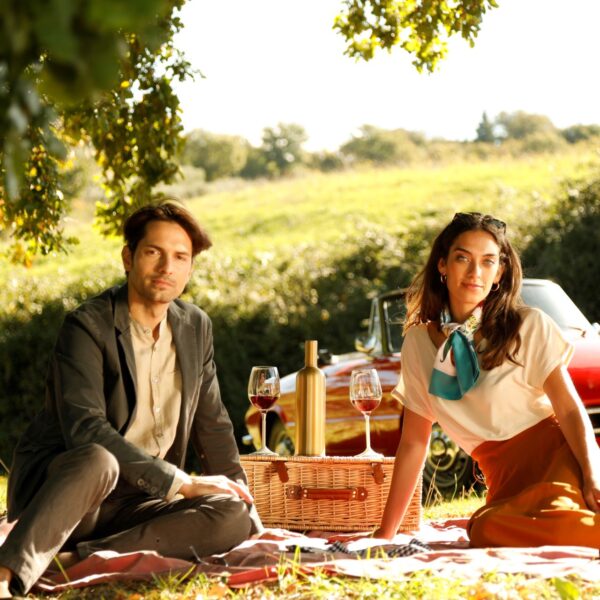 elegant sunset scene of a couple with wine glasses filled with white wine